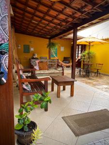 een patio met banken, een tafel en een parasol bij MAI Chameguin Hospedagens Paraty in Paraty