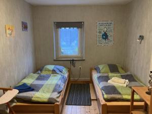2 camas en una habitación con ventana en Ferienwohnung Marienhof OG, en Seelbach