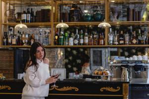 a woman standing in a bar holding a glass at Hotel Gravina 51 in Seville