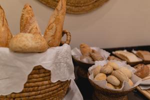 a table topped with baskets filled with bread at Hotel Gravina 51 in Seville
