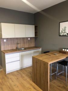 a kitchen with white cabinets and a wooden table at Bureau Residence in Kartepe