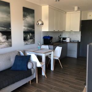 a kitchen and living room with a couch and a table at Apartament Julian Seaside Gardenia in Dziwnów