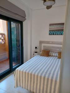 een slaapkamer met een bed en een groot raam bij Vera Playa Naturista Michel in Vera