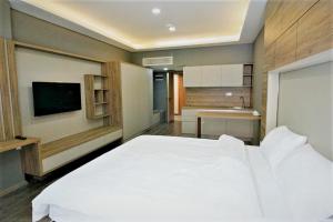 a bedroom with a large white bed and a bathroom at Bureau Residence in Kartepe