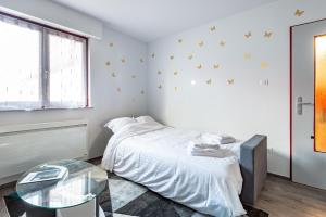 1 dormitorio con cama y mesa de cristal en Halte de la Commanderie en Colmar