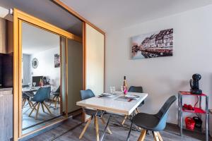 科爾馬的住宿－Halte de la Commanderie，一间带桌椅和镜子的用餐室