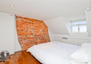 a bedroom with a brick wall and a bed at Central Apartment Bedford Loft in Worthing