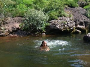 a woman is swimming in a river at Posada Rural Lindos Sueños in La Lomba
