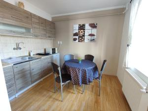 una cucina con un tavolo e sedie in una stanza di Katalin Apartmanház a Miskolctapolca Altre 19 foto