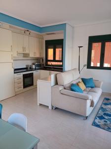 a living room with a couch and a kitchen at Vera Playa Naturista Michel in Vera