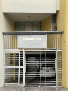 a dog sitting behind a gate in a building at Exclusivo Apartamento en el corazón de Trujillo in Trujillo