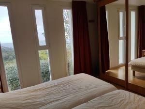 ein Schlafzimmer mit einem Bett und einem großen Fenster in der Unterkunft Villa Laia-clim-WIFI- vue mer in Conca