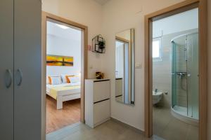 łazienka z prysznicem oraz sypialnia z łóżkiem w obiekcie Apartments Greta & Ivona w Puli