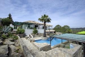 a house with a swimming pool and a palm tree at Villa Metacasa by Portucasa in Santa Catarina da Fonte do Bispo