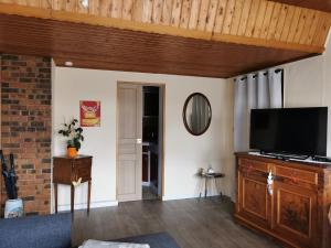 a living room with a flat screen tv on a wooden cabinet at Au repos des remparts in Wissembourg