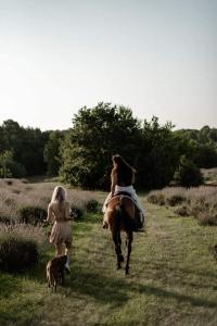 Martinski的住宿－Golden Valley apartment & ranch，野地里与狗一起骑马的女人