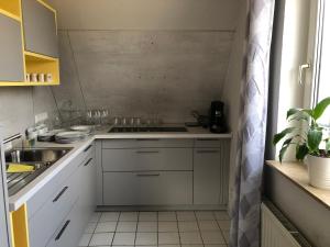 a small kitchen with white cabinets and a sink at Ferienwohnung Seeblick Ratzeburg in Ratzeburg +33 photos