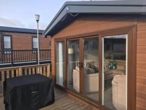 a screened in porch with a couch on a deck at Number 47 @ Lilliardsedge in Jedburgh