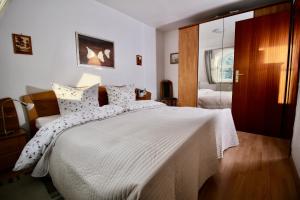 - une chambre dotée d'un grand lit avec des draps et des oreillers blancs dans l'établissement Parkside No 8, à Timmendorfer Strand