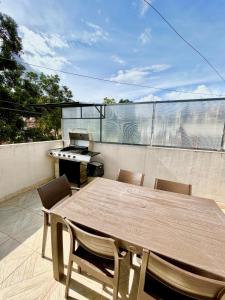 een tafel en stoelen op een balkon met een grill bij VFC Suites Cuenca - Ecuador in Cuenca