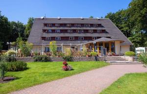 a large building with a lawn in front of it at Forsthaus Langenberg in Bansin