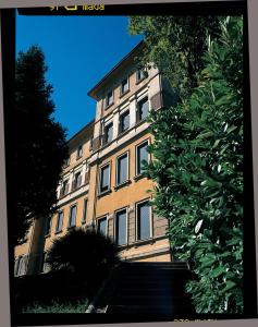 a large yellow building with stairs in front of it at Hotel Valentini in Salsomaggiore Terme