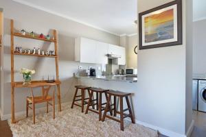 a kitchen with a table and chairs and a counter at Penguin Haven . Luxury 2 bedroom, Boulders Beach. in Cape Town