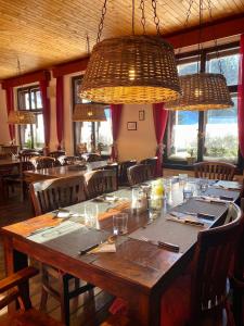 ein Esszimmer mit einem großen Holztisch und Kronleuchtern in der Unterkunft Hotel Petski in Strážné