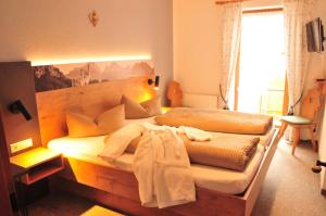 a bedroom with a large bed with a wooden headboard at Pension Vendel in Pfronten