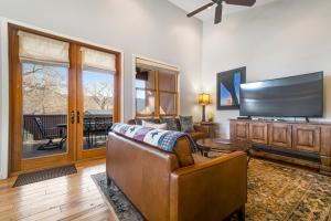 uma sala de estar com um sofá e uma televisão de ecrã plano em Moab Springs Ranch 7 em Moab