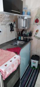 a small kitchen with a sink and a microwave at Hostel Cidade Nova, próximo a estação metrô praça 11, onde você tem acesso direto a quaisquer Shows nas praias da zona Sul in Rio de Janeiro