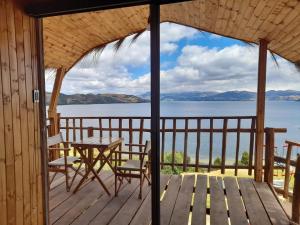 una mesa y sillas en una terraza con vistas al agua en BluGlamp PlayaBlanca, en Boyacá