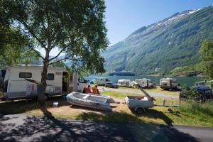 a group of people sitting in front of a camp site at Geirangerfjorden Feriesenter in Geiranger