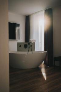 a bath tub sitting on a wooden floor in a bathroom at Sombea in Villingen-Schwenningen