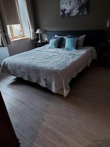 um quarto com uma cama com almofadas azuis em B&B Le Notaire em Bomal