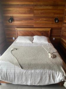 uma cama com um gato sentado em cima dela em Cabana Guimarães em Rancho Queimado