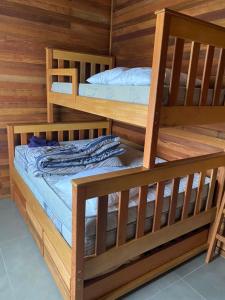 2 beliches num quarto com paredes de madeira em Cabana Guimarães em Rancho Queimado