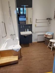 uma casa de banho com um lavatório e uma banheira em B&B Le Notaire em Bomal