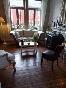 uma sala de estar com um sofá e uma mesa de centro em B&B Le Notaire em Bomal