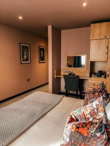 1 dormitorio con cama y escritorio en The Stratford Park Hotel & Golf Club, en Stratford-upon-Avon