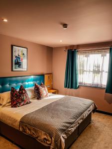 Un dormitorio con una cama grande y una ventana en The Stratford Park Hotel & Golf Club, en Stratford-upon-Avon