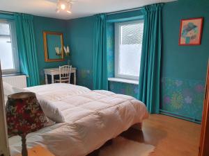 a bedroom with blue walls and a bed and a chair at Sur la Rive Vierre in Suxy