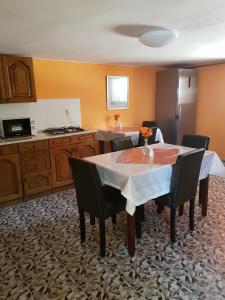 a kitchen with a table and chairs and a kitchen with a counter at Vincze Villa Vendégház in Bükkszék