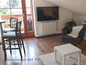 uma sala de estar com duas cadeiras e uma televisão em BESTE ZEIT Ferienwohnung em Grassau