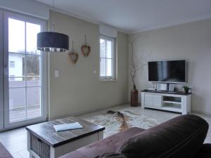 ein Wohnzimmer mit einem Sofa und einem Flachbild-TV in der Unterkunft Ferienwohnung LP8 "Deck Zwei" in Graal-Müritz