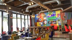 um restaurante com mesas e cadeiras e paredes coloridas em Reef Hotel em Joanesburgo