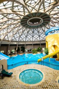 een groot zwembad in een groot gebouw bij Suites Hôtel Les Charmilles & Spa in La Marsa