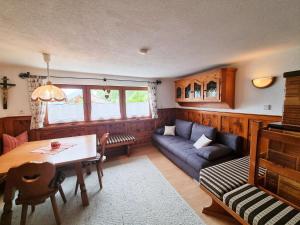 uma sala de estar com um sofá e uma mesa em Holiday Home Egger - ZAZ379 by Interhome em Aschau