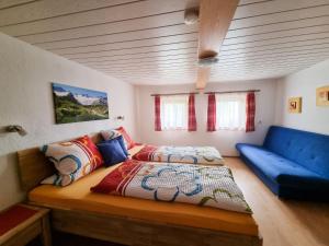 um quarto com uma cama e um sofá azul em Holiday Home Egger - ZAZ379 by Interhome em Aschau