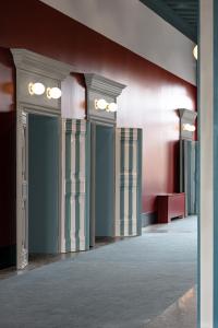 un couloir avec des colonnes et un mur rouge dans l'établissement Il Palazzo Experimental, à Venise